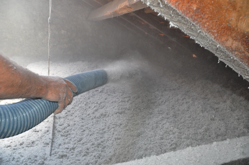 Intérieur d'un grenier en cours d'isolation thermique par soufflage de ouate de cellulose