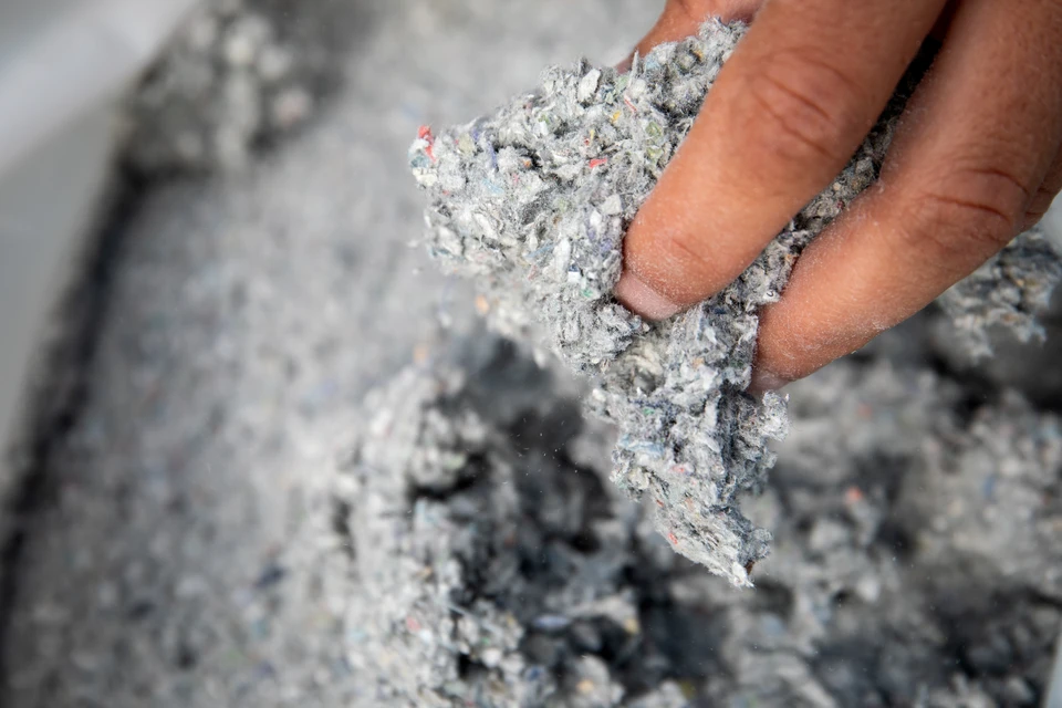 Surface textile blanche froissée avec plis et ondulations naturelles créant des zones d'ombre et de lumière